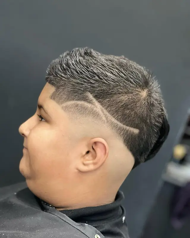 Kid’s skin fade with a shaved design