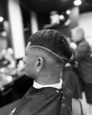 Low skin fade with a shaved line design